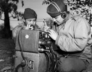 Two service members listen to a WWII radio